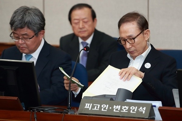 110억 원대 뇌물수수와 350억 원대 다스 자금 횡령 등 혐의로 구속기소 된 이명박 전 대통령이 23일 오후 서울 서초구 서울중앙지방법원 417호 대법정에서 열린 첫 정식재판에 출석, 자료를 보고 있다. (사진=newsis)